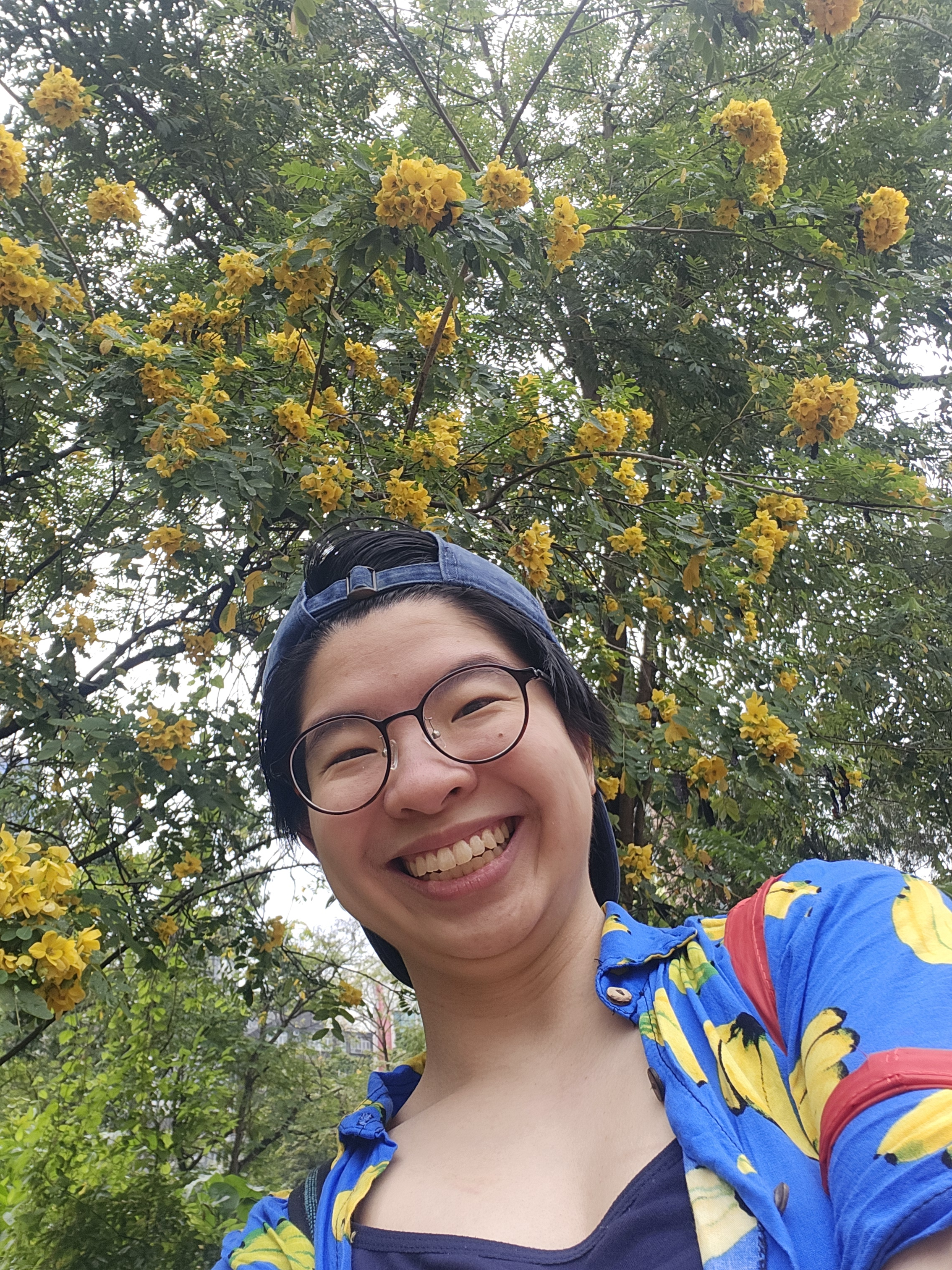 Portrait of Vanessa, an Asian woman with glasses smiling into the camera.